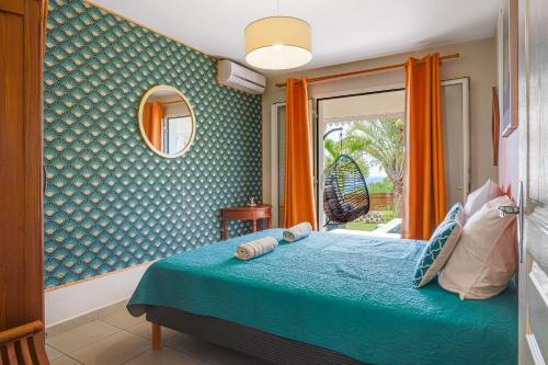 a bedroom with a bed and a window at Terre des îles - Grande Anse - lodges avec piscines privées in Petite Île