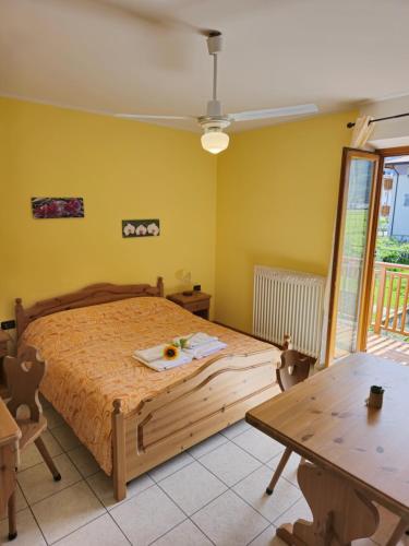 1 dormitorio con cama de madera y mesa en Antico Fienile Agritur en Mezzocorona