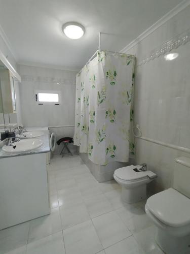 a bathroom with a toilet and a shower curtain at Miradoralaribera Chalet rural in Alcoba de la Ribera