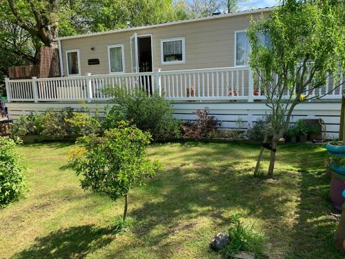 a house with a white fence and a yard at Shangri la at Beauport in Westfield