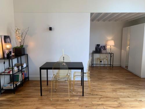 une salle à manger avec une table et des chaises noires dans l'établissement Superbe appartement Tour Eiffel, à Paris