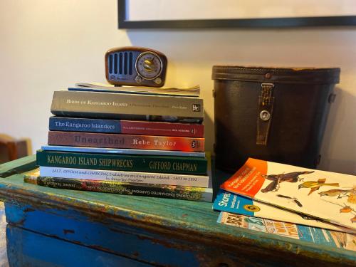 a stack of books sitting on top of a dresser at Sheoak Lodge in Penneshaw