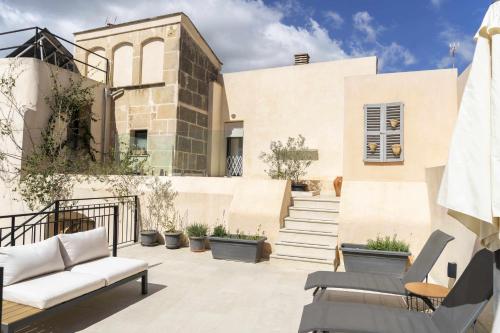 eine Terrasse mit Gartenmöbeln und eine Treppe vor einem Gebäude in der Unterkunft Atrium Suites Mallorca in Porreres