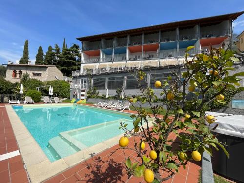 a swimming pool with an orange tree in front of a building at Hotel Roma Aparthotel in Malcesine