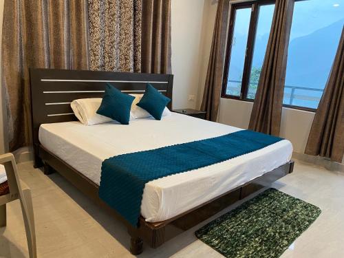Gupta KāshiHotel Rajshree Palace的一间卧室，配有一张带蓝色枕头的床和一扇窗户