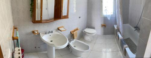 uma casa de banho branca com um lavatório e um WC em Casa ichnusa 8 em Santa Teresa Gallura