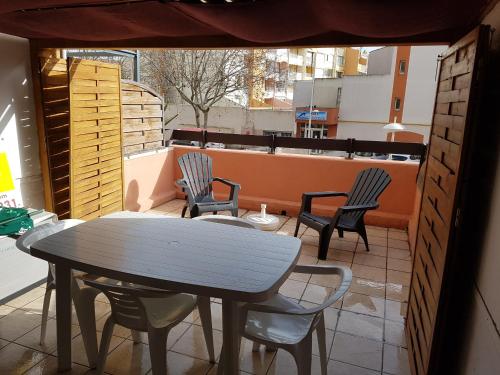 un patio avec une table et des chaises sur un balcon dans l'établissement Studio place Saint clair, au Cap d'Agde