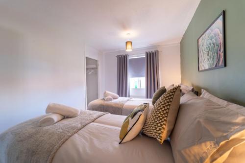 a bedroom with two beds and a window at Spacious 3 Bed House, 5mins to HS2/ NEC/Airport. in Marston Green