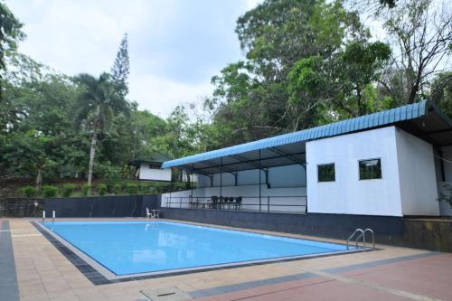 a building with a swimming pool in front of it at Sankara Resort in Ratnapura