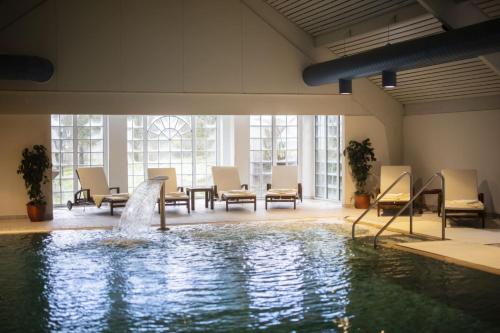 a swimming pool with a fountain in a building at Romantikhotel Platte in Attendorn