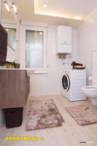a bathroom with a washing machine and a sink at Residence 14 Sarajevo in Sarajevo