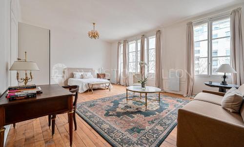 un salon avec un canapé et une table dans l'établissement Appartement Paris 7ème Invalides/ Tour Eiffel 1er étage, à Paris