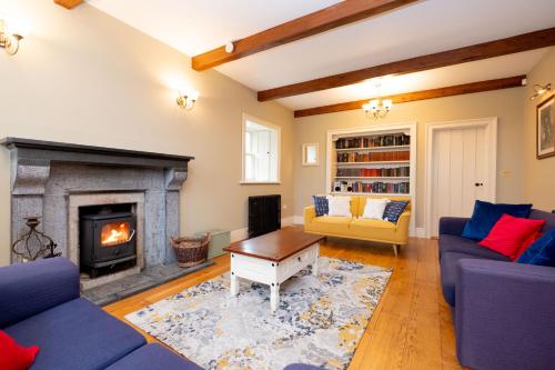 a living room with a fireplace and blue couches at Historic Luxury House in Corrofin