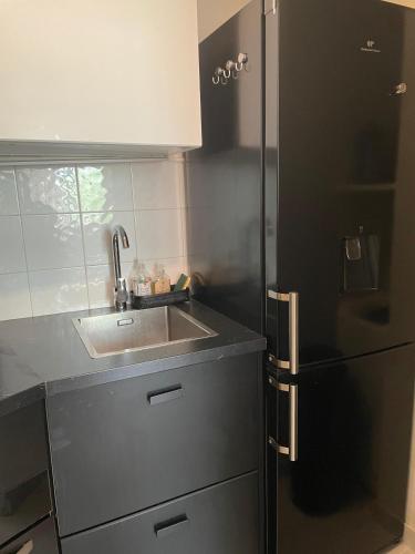 une cuisine avec un évier et un réfrigérateur dans l'établissement Appartement Paris 7ème Invalides/ Tour Eiffel 1er étage, à Paris