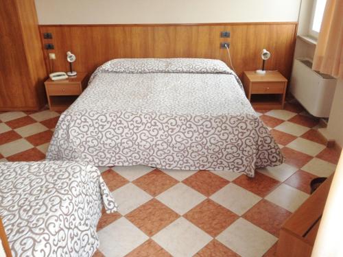 a bedroom with a bed and a checkered floor at Hotel Daina in Dalmine
