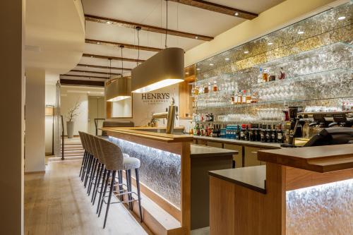 a restaurant with a bar with stools at Romantikhotel Platte in Attendorn