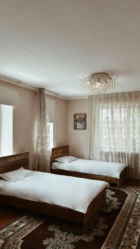 a bedroom with two beds and a chandelier at 长城民宿34号院 in Almaty