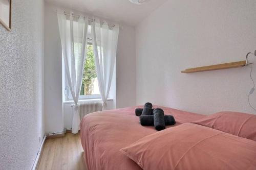 - un ours en peluche assis sur un lit dans une chambre dans l'établissement Le Coquelicot- Coquet, à Mulhouse