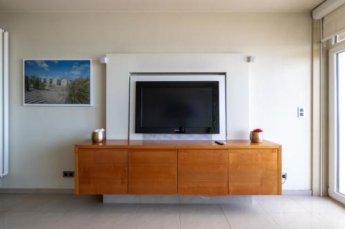 a living room with a television on a wooden dresser at BEL AIR HOLIDAY - 3 Bedroom Apartment with Sauna and Phenomenal Sea View T72 in Ostend