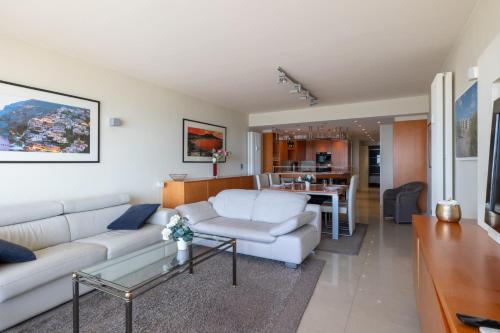 a living room with a white couch and a table at "Romantica" - Luxury Apartment with infrared cabin and Seaview T72 in Ostend