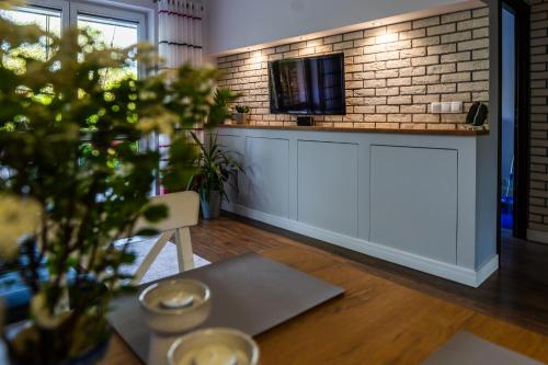 a kitchen with a table with a tv on a brick wall at Rodzinny relaks z ogrodem i garażem in Warszawa