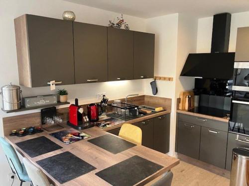 - une cuisine avec une table en bois dans l'établissement Appartement calme, jardin, 4 pers, Proche plage et commerces, Parking, Normes Handicapés - FR-1-494-167, à Royan