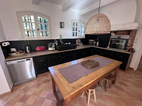 - une cuisine avec une table en bois et un évier dans l'établissement Maison avec Piscine Privée, Climatisation et Vue Mer - FR-1-768-69, à Saint-Peïre-sur-Mer