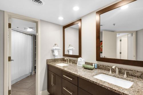 a bathroom with two sinks and two mirrors at East Pass 101 in Destin