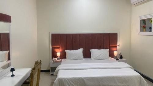 um quarto com uma cama grande e uma cabeceira em madeira em فواصل الشمال em Rafha