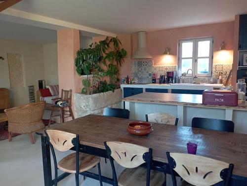 una cucina con un tavolo di legno e alcune sedie di Maison de campagne La Teranga au coeur du Luberon ad Apt