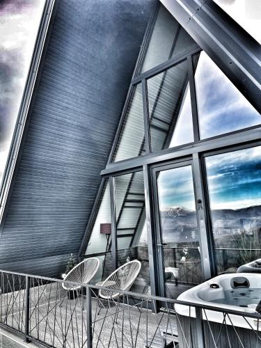 a building with two chairs and a table on a balcony at Jahorina Luxury Chalets in Jahorina