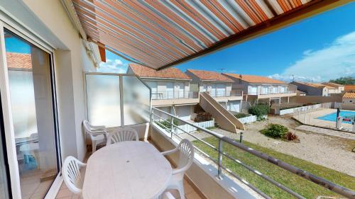 un balcon avec une table et des chaises et une vue dans l'établissement Le Jardin de la mer 150 plage, à Plage-des-Demoiselles