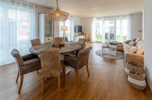 a living room with a wooden table and chairs at 5 Sterne Ferienhaus Ostseenest mit Boddenblick in Fuhlendorf