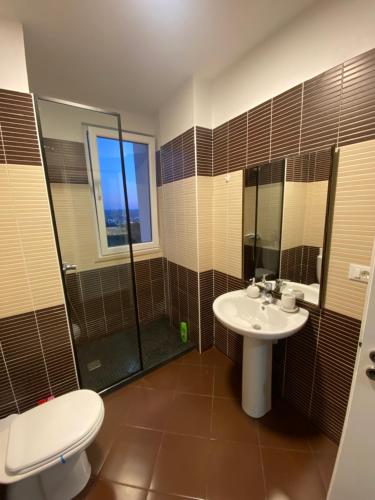 a bathroom with a toilet and a sink and a shower at Sunny Home overlooking Tirana in Tirana