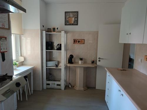 a kitchen with white cabinets and a table in it at Sweet House in Lisbon