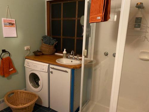 a bathroom with a washing machine and a sink at Sheoak Lodge in Penneshaw