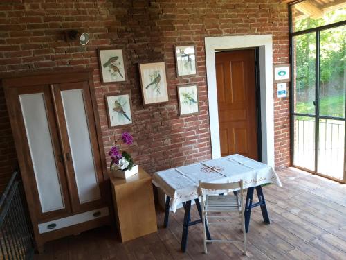 a room with a table and a brick wall at B&B Il vecchio pero in Capriglio