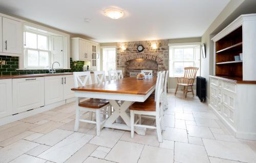 a kitchen with a table and chairs and a fireplace at Historic Luxury House in Corrofin