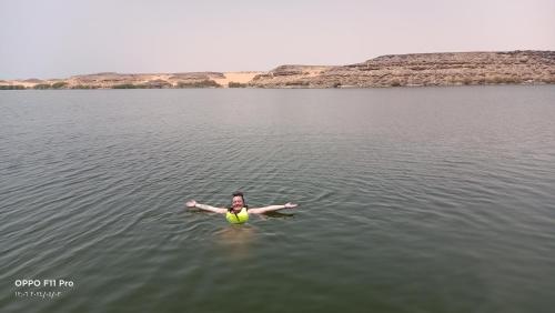 a woman swimming in a body of water at Amon guest house in Abu Simbel