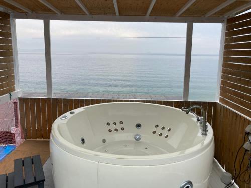 bañera en una habitación con ventana grande en プチリゾート・ひじきwest, en Hijiki