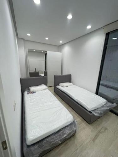 two beds in a room with a mirror at Apartment in Tirana with view in Tirana