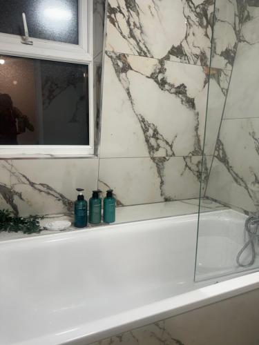 ein Bad mit einer Badewanne und einem Fenster in der Unterkunft Unique 2 bedroom Apartment 15 mins via tube to Central London in London