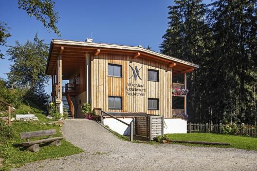 a log cabin with a sign on the side of it at Appartement Waldhäusl in Neukirchen am Großvenediger