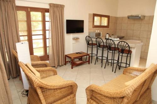 salon z krzesłami oraz kuchnia ze stołem w obiekcie CFM Sociedade Turística Bilene Resort w mieście Vila Praia Do Bilene