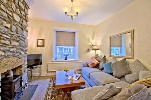 een woonkamer met een bank en een open haard bij Labernum Cottage, Ingleton, Yorkshire Dales National Park, Famous Three Peaks, Near The Lake District, Pets Are Welcome in Ingleton 