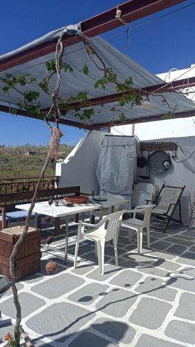 a patio with a table and chairs under a tent at Smaragda home in Liaropá