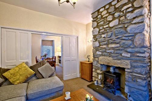 a living room with a large stone fireplace at Labernum Cottage, Ingleton, Yorkshire Dales National Park 3 Peaks and Near the Lake District, Pet Friendly in Ingleton