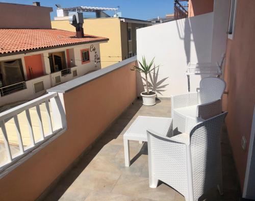 a balcony with a table and chairs on a building at Il Bed and Breakfast al Centro in Castelsardo