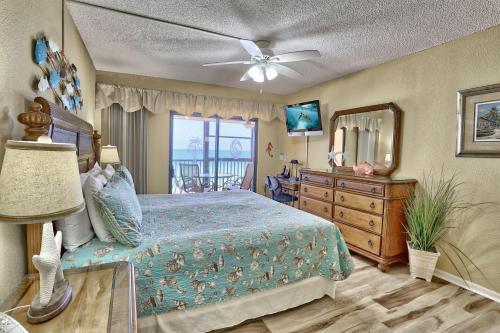a bedroom with a bed and a dresser and a mirror at Villa Madeira 506 - Premier in St. Pete Beach