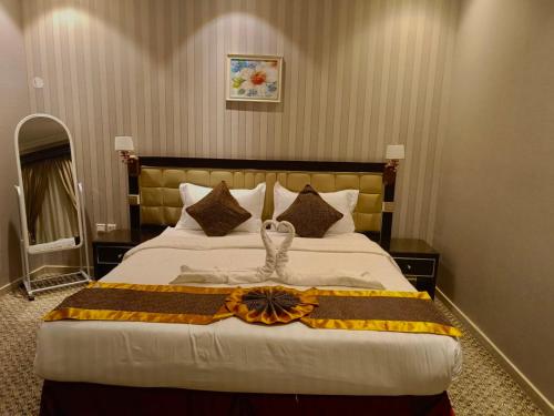 a hotel room with a large bed with a dress on it at فندق بيوتات المروة biutat almarwa in Jeddah